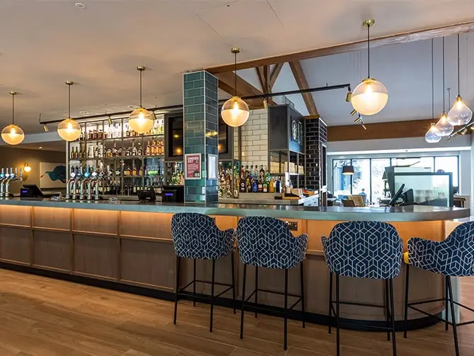 The image shows the Holiday Inn Cambridge bar area after LED lighting upgrade project by Lightsave Projects.