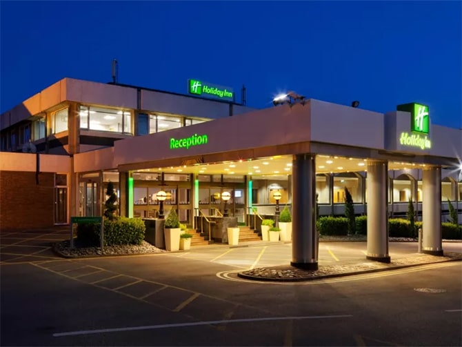 Image shows the Holiday Inn, Maidenhead main entrance at night with lighting on show